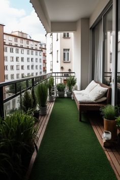 a balcony with green grass and potted plants on the floor, next to a couch