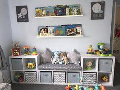 a child's room with toy storage bins and toys on the wall above