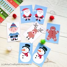 christmas cards with pictures of santa, snowman and reindeer on them sitting on a table