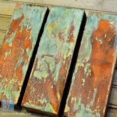 three pieces of wood that have been painted green and orange with rusted paint on them