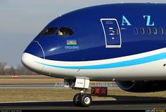 a blue and white airplane is on the runway