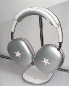 a pair of silver headphones sitting on top of a white table next to a mirror