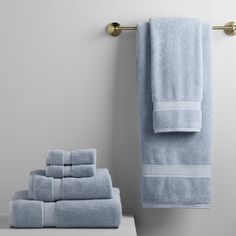 a stack of blue towels sitting on top of a counter next to a towel rack