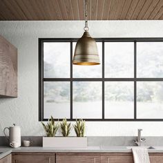 a modern kitchen with wooden cabinets and white counter tops, an island style sink and hanging light fixture