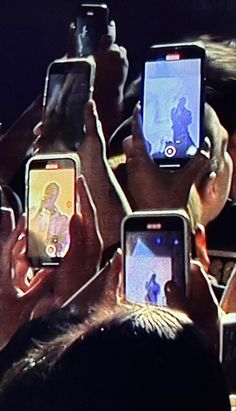 several people holding up their cell phones with pictures on them