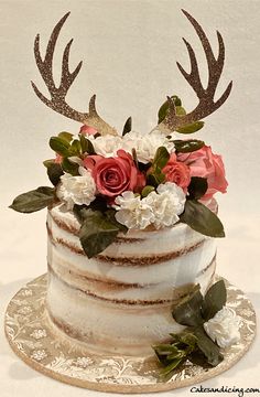 a wedding cake decorated with flowers and antlers