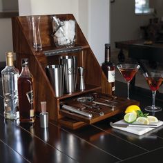 an assortment of liquors and cocktail glasses sit on a bar counter with alcohol in the foreground