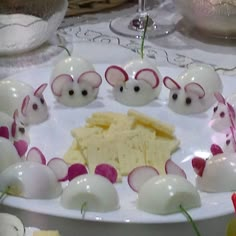 some little mice are on a plate with cheese and radishes in the middle