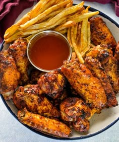 chicken wings and french fries on a plate with ketchup