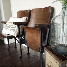 two brown chairs sitting next to each other on top of a hard wood floor in front of a vase filled with flowers