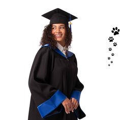 a woman wearing a graduation cap and gown with paw prints on the wall behind her