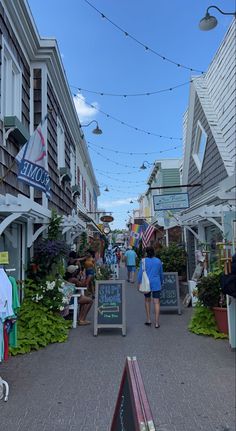 people are walking down the street in front of shops