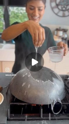 a woman stirring something in a bowl on top of an open burner with water