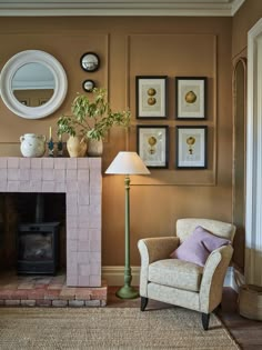 a living room with a chair, fireplace and pictures on the wall above it's mantle