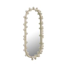 a white mirror that has balls on the frame and is shaped like an oval shape