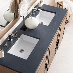 two sinks are shown in front of a mirror