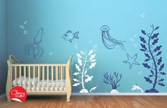 a baby's room with a crib and wall decals