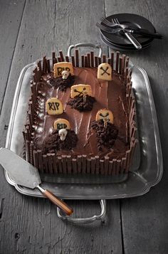 a cake with chocolate frosting and decorations on it, sitting on a tray next to a spatula