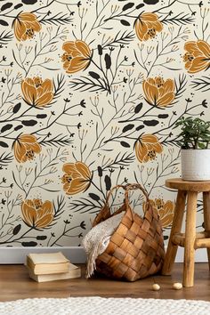 a basket sitting on top of a wooden floor next to a wallpaper covered in flowers