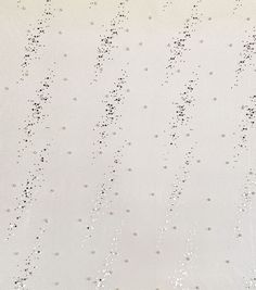 a white wall with lots of black dots on it