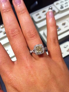 a close up of a person's hand with a diamond ring on their finger