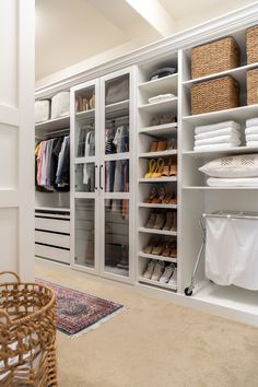 an organized closet with white shelving and wicker baskets on the floor, including shoes