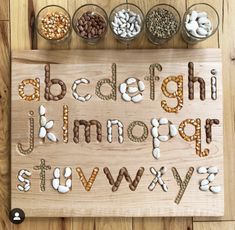 a wooden board with letters and numbers made out of nuts, beans, and other things