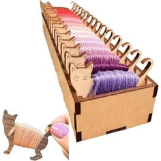 a wooden box filled with yarn and a cat figurine