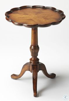 an antique wooden table with carved legs and a tray on the top that is turned upside down