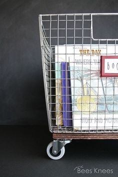 a shopping cart filled with books on top of a black table next to a chalkboard