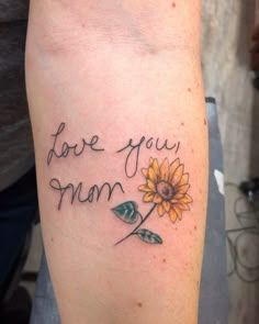 a sunflower with the words i love you mom tattooed on it's leg