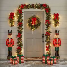 two nutcrackers are standing in front of a door decorated for christmas