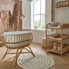 a baby's room with an oval crib and wicker furniture