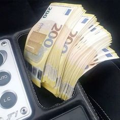 a bunch of money sitting inside of a black case next to a remote control controller