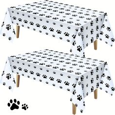 two dog paw prints tablecloths on top of a white table cloth with wooden legs