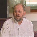 a man in white shirt and tie sitting down