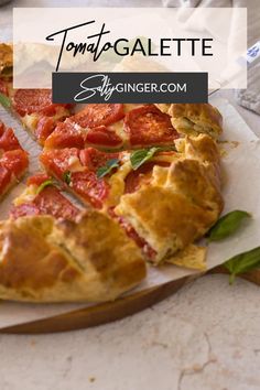 a pizza with tomatoes on it sitting on top of a cutting board