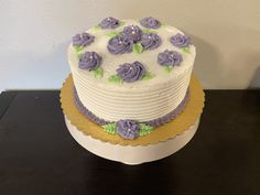 a white and purple cake sitting on top of a table