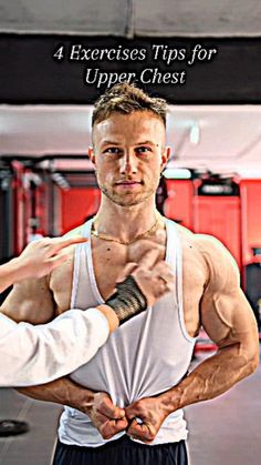 a man is showing off his muscles in the gym with another man standing behind him