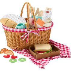 a picnic basket filled with food on top of a red and white checkered cloth