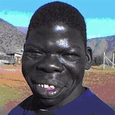 a man is smiling for the camera in front of mountains