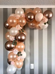 the balloon arch is decorated with flowers and balloons for an elegant touch to any room