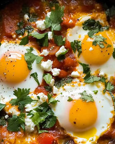 three eggs are in a skillet with tomatoes, cheese and cilantro sauce