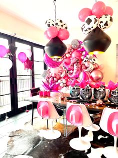 a dining room filled with lots of pink and black balloons in the shape of animals