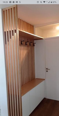 an empty room with wooden slats on the wall and white cupboards in it