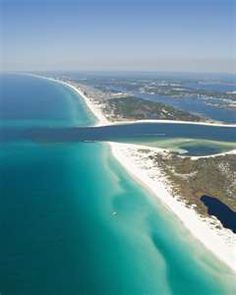 an aerial view of the beach and ocean with blue water, sand and white sand