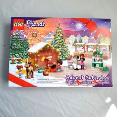 the lego friends christmas calendar is displayed in front of a snowy scene with toys and presents