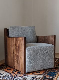 a gray chair sitting on top of a rug