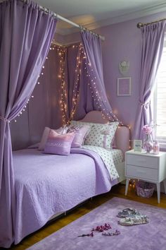 a bedroom decorated in purple and white with fairy lights on the curtains, bedding and rugs