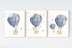 three blue hot air balloons in the sky with animals on them, one is flying